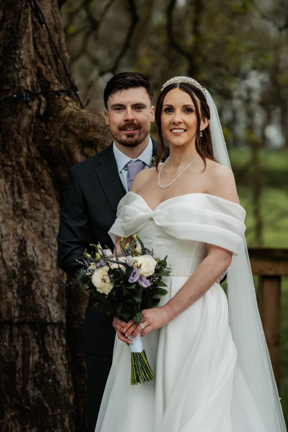 Relaxed bride and groom portrait standing in front of the ancient tree on Stirk House grounds.