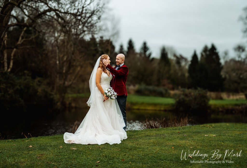 Stunning outdoor wedding portrait of Katie and Mathew by the lake at The Oak Tree of Peover showcasing affordable wedding photography