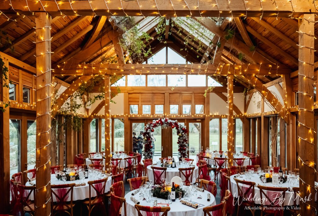 Stunning wedding breakfast setup with fairy lights and rustic high ceilings inside the barn at The Oak Tree of Peover