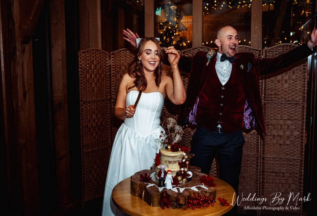 The bride and groom excitedly preparing to cut the wedding cake. You can see the custom cake toppers and the joy on their faces as they celebrate the moment