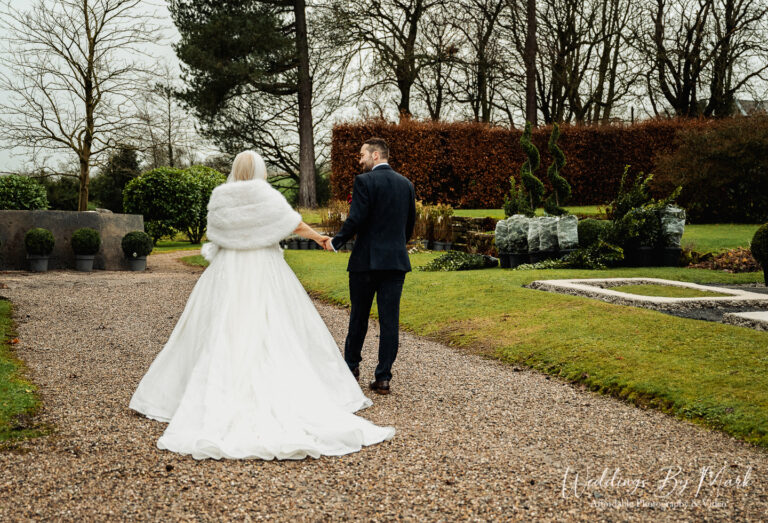 Maria and Jonny embracing in the winter light outside Eaves Hall, Lancashire wedding photography.