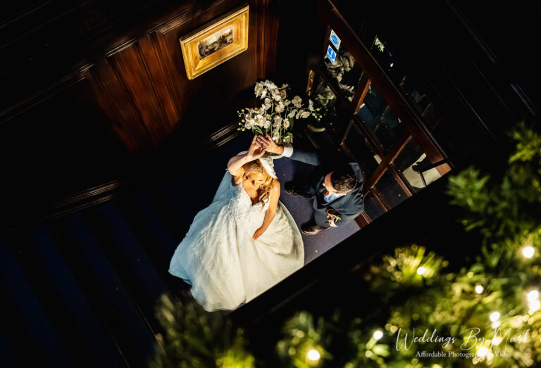 Bride and Groom posing on the grand staircase at Eaves Hall during their winter wedding in the Ribble Valley