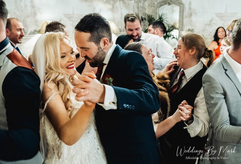 Natural and candid wedding photo of bride and groom laughing during their Eaves Hall winter celebration.